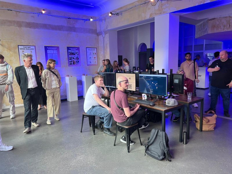 Busy MX Mind Gallery room with participants at the EEG stations