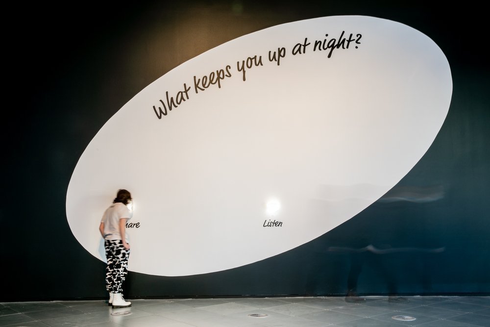 Fear Exchange installation wall asking 'What keeps you up at night?' with 'Share' and 'Listen' points
